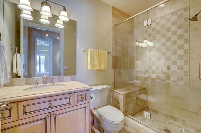 a kitchen with stainless steel appliances granite countertop a stove top oven a sink dishwasher and a refrigerator with wooden floor