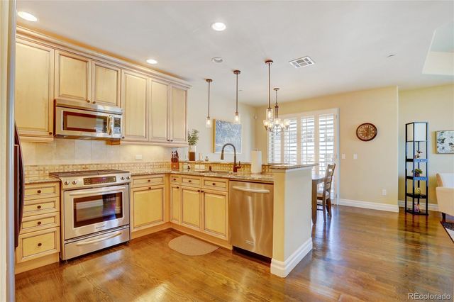 a kitchen with stainless steel appliances granite countertop a stove a sink and a refrigerator