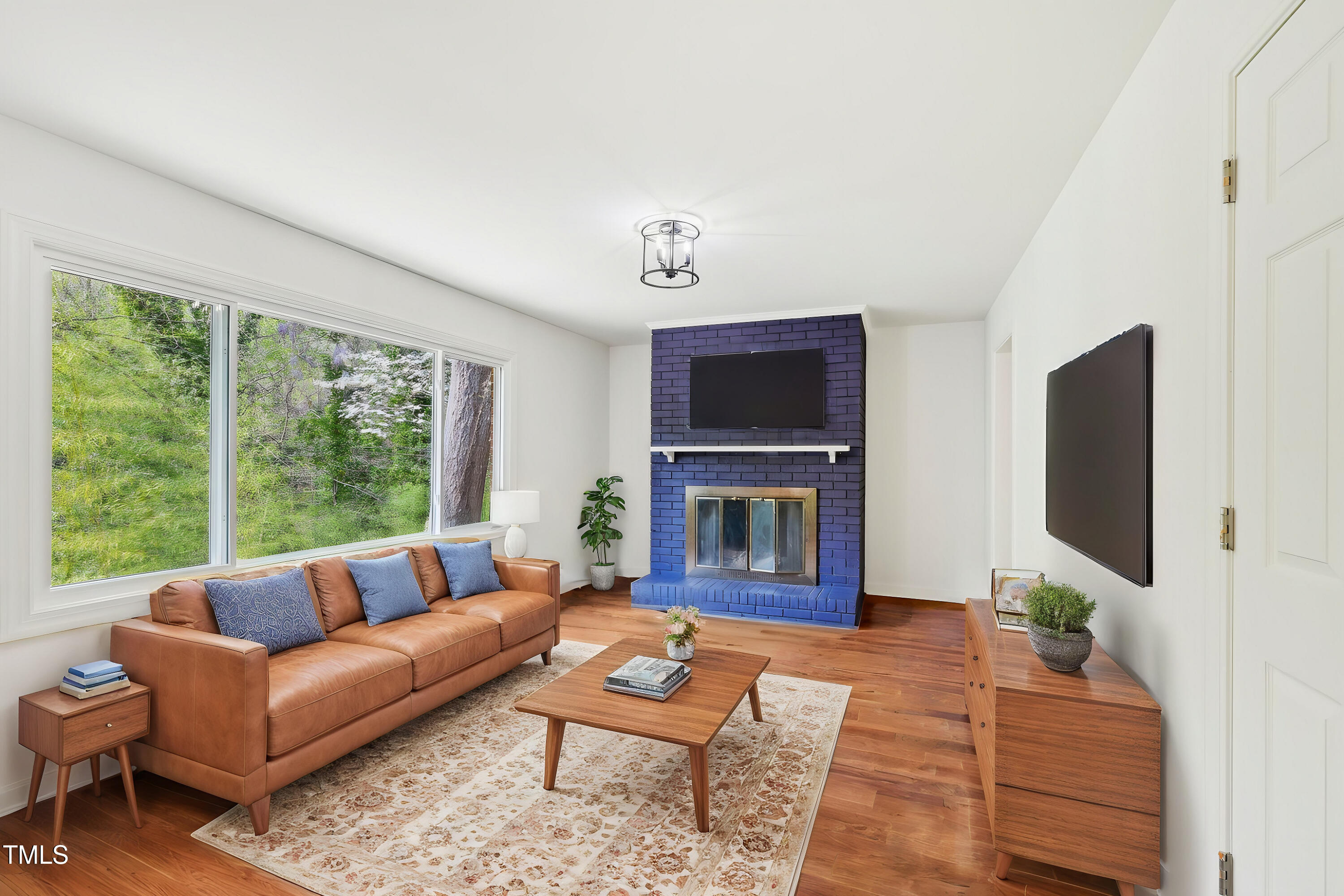 4815 Oak Park Road Raleigh, NC 27612 - Photo 14 of 50 a living room with furniture a flat screen tv and a fireplace
