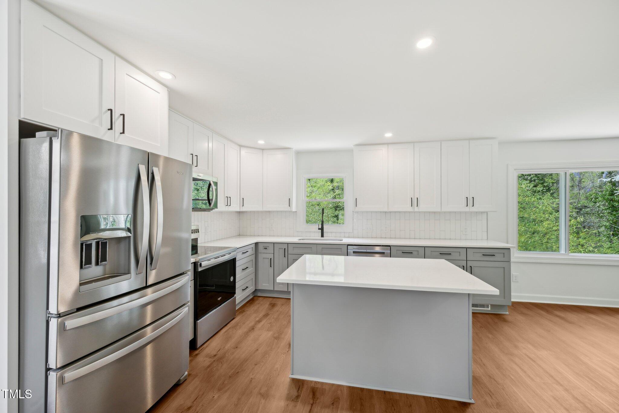 4815 Oak Park Road Raleigh, NC 27612 - Photo 16 of 50 a kitchen with a refrigerator sink and cabinets