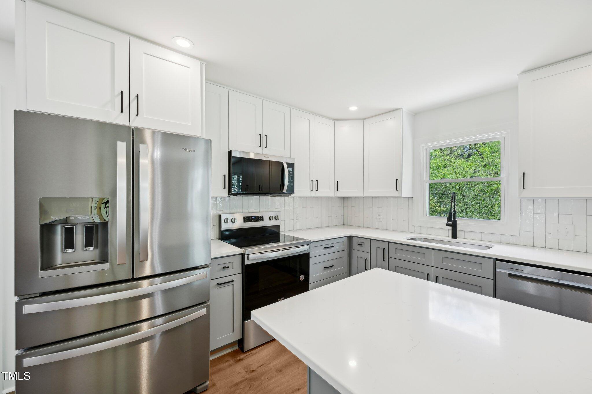 4815 Oak Park Road Raleigh, NC 27612 - Photo 17 of 50 a kitchen with granite countertop white cabinets and stainless steel appliances
