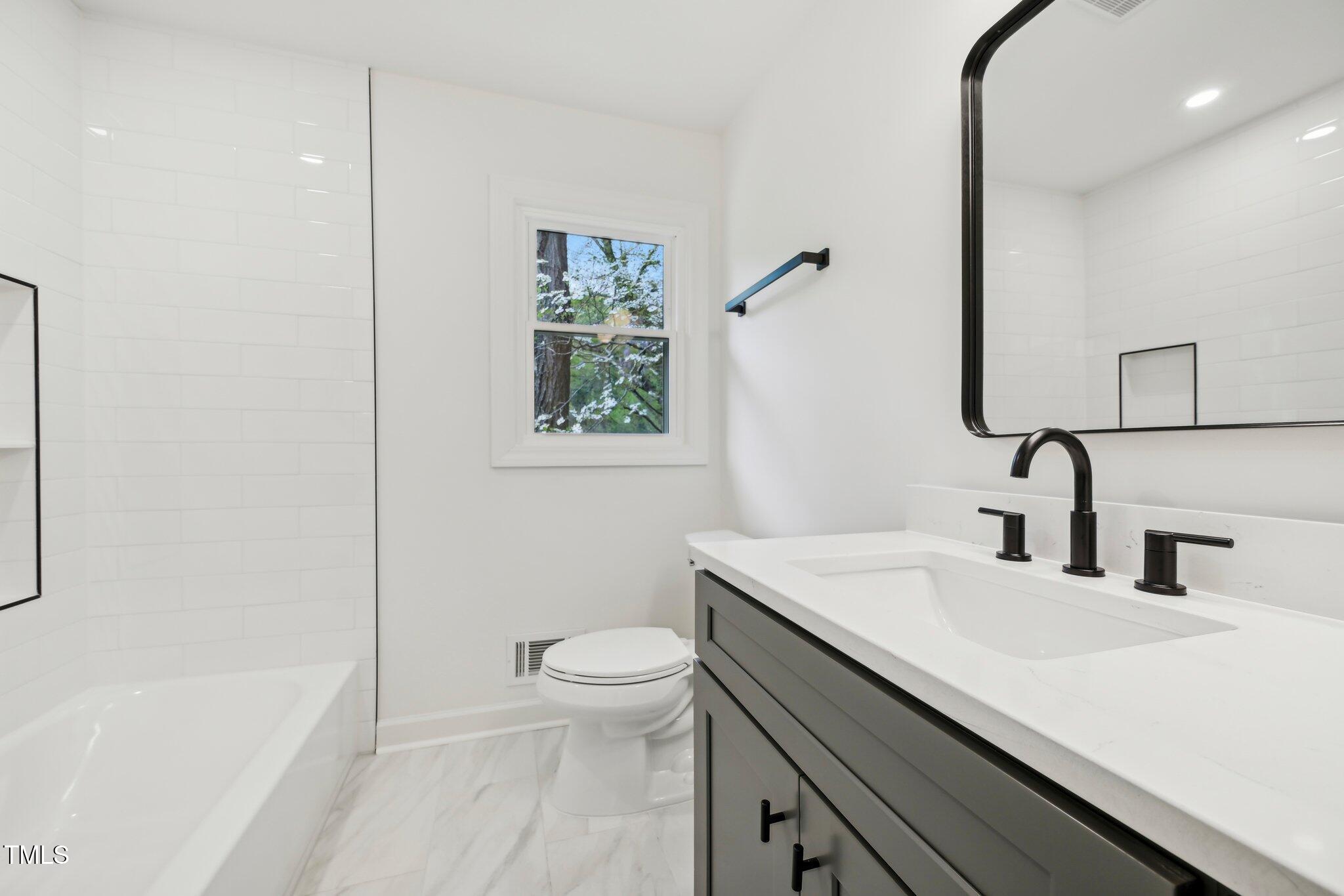 4815 Oak Park Road Raleigh, NC 27612 - Photo 25 of 50 a bathroom with a sink a toilet and shower