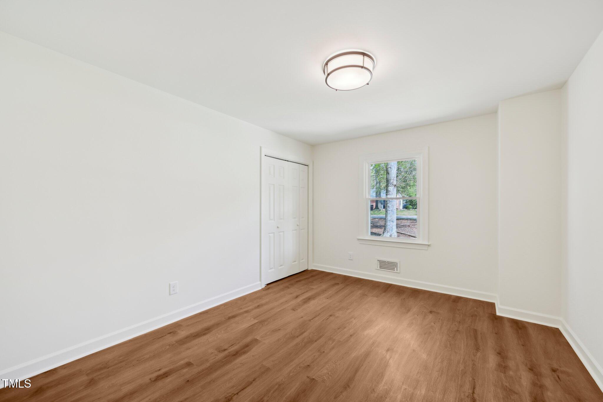 4815 Oak Park Road Raleigh, NC 27612 - Photo 28 of 50 an empty room with wooden floor and windows