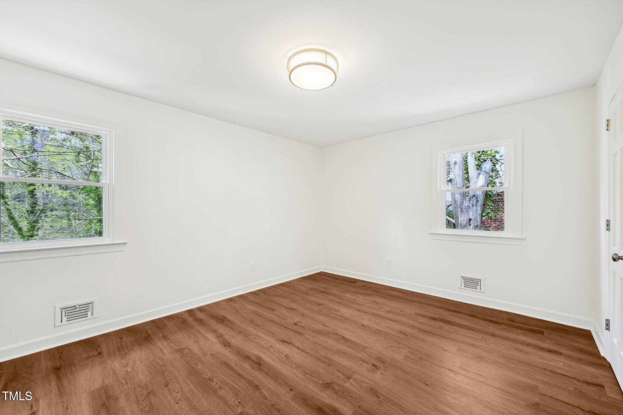 4815 Oak Park Road Raleigh, NC 27612 - Photo 33 of 50 an empty room with wooden floor and windows