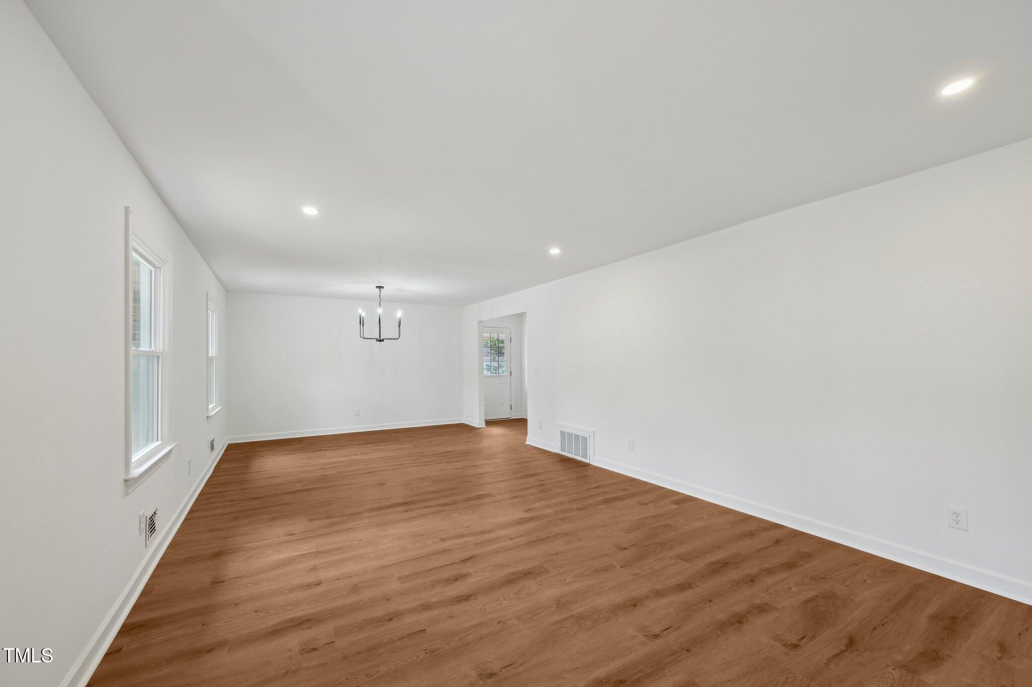 4815 Oak Park Road Raleigh, NC 27612 - Photo 6 of 50 an empty room with wooden floor and windows