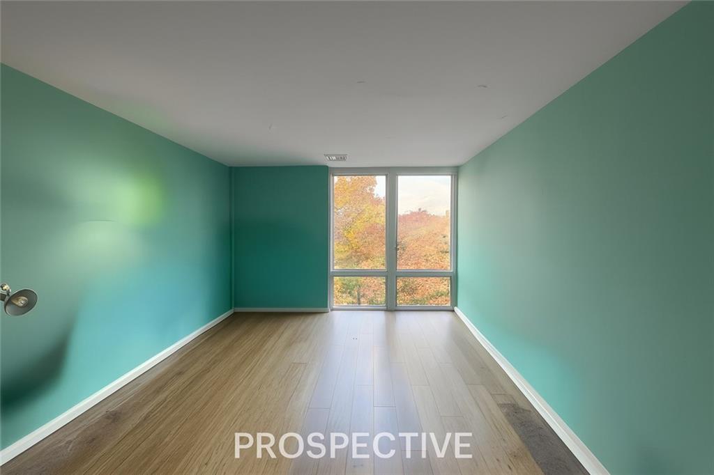 5100 Fifth Avenue, Unit 509 Pittsburgh, PA 15232 - Photo 16 of 26 a view of an empty room with wooden floor and a window