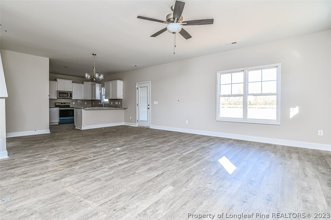 672 Barlow Road Parkton, NC 28371 - Photo 2 of 17 a view of a kitchen with a stove cabinets a ceiling fan and wooden floor