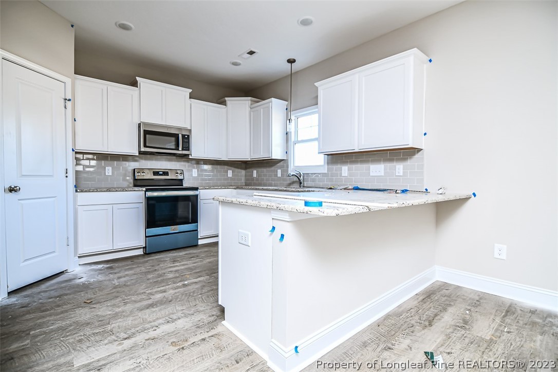 672 Barlow Road Parkton, NC 28371 - Photo 4 of 17 a kitchen with stainless steel appliances a sink dishwasher a stove top oven a refrigerator and cabinets