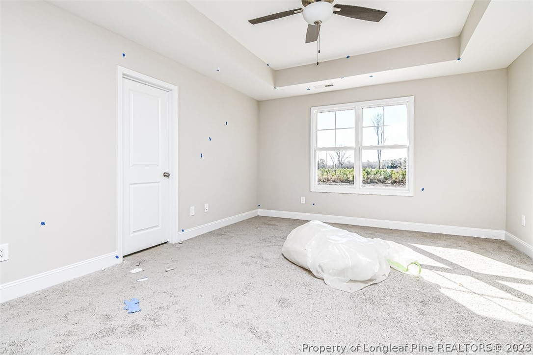 672 Barlow Road Parkton, NC 28371 - Photo 6 of 17 an empty room with chandelier fan and windows