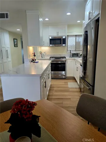 a kitchen with stainless steel appliances a refrigerator sink and cabinets