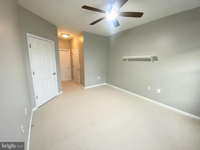 an empty room with closet and fan