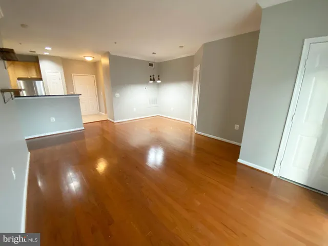 a view of an empty room with wooden floor