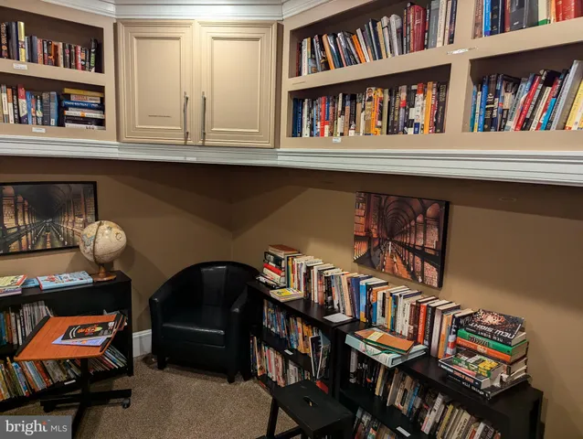 a living room with furniture and a book shelf