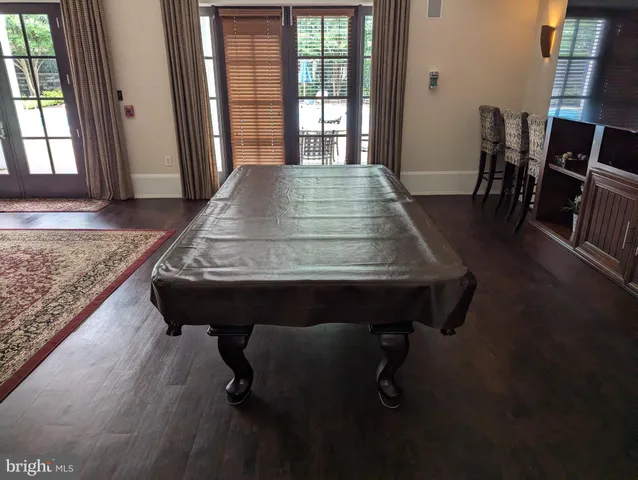a room with pool table and windows