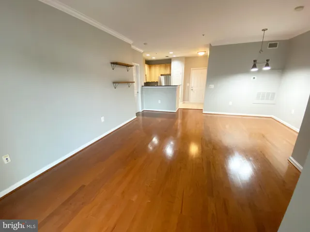 a view of empty room with wooden floor