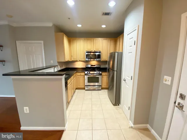a kitchen with stainless steel appliances granite countertop a refrigerator sink and cabinets