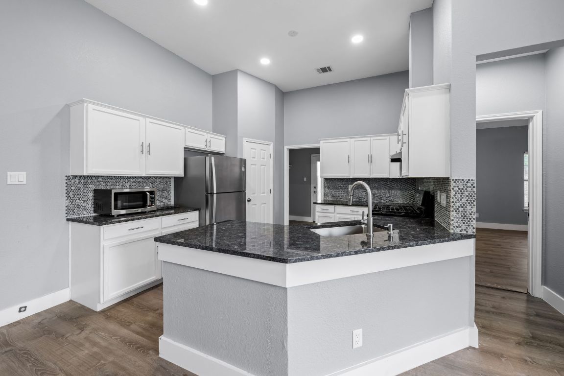 1214 Vargas Road, Unit B Austin, TX 78741 - Photo 8 of 25 a kitchen with stainless steel appliances granite countertop a refrigerator a stove a sink and a microwave