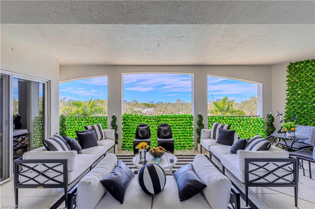 a living room with furniture potted plant and a large window