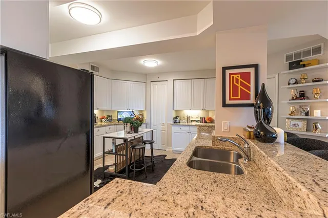 a kitchen with a refrigerator and a stove top oven