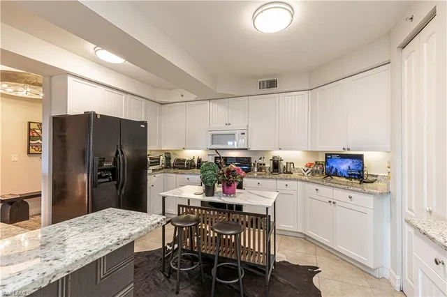 a kitchen with a refrigerator a stove and a dining table with wooden floor