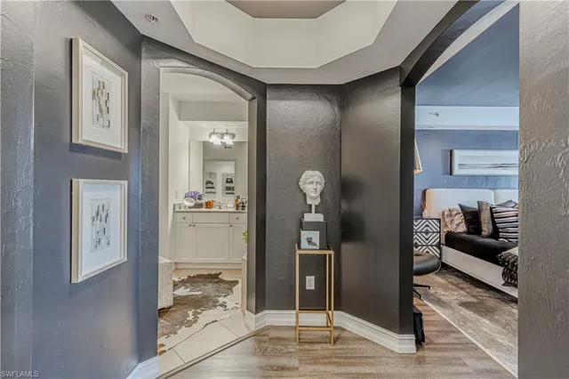 a view of a hallway with wooden floor and a living room