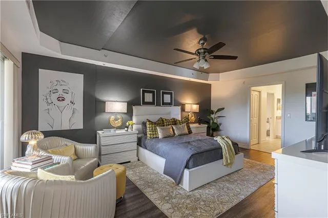 a bedroom with a bed couches and chandelier