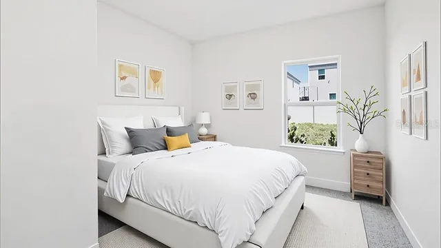 a bedroom with a bed plant and cabinets
