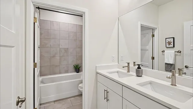 a bathroom with a bathtub shower sink vanity and mirror