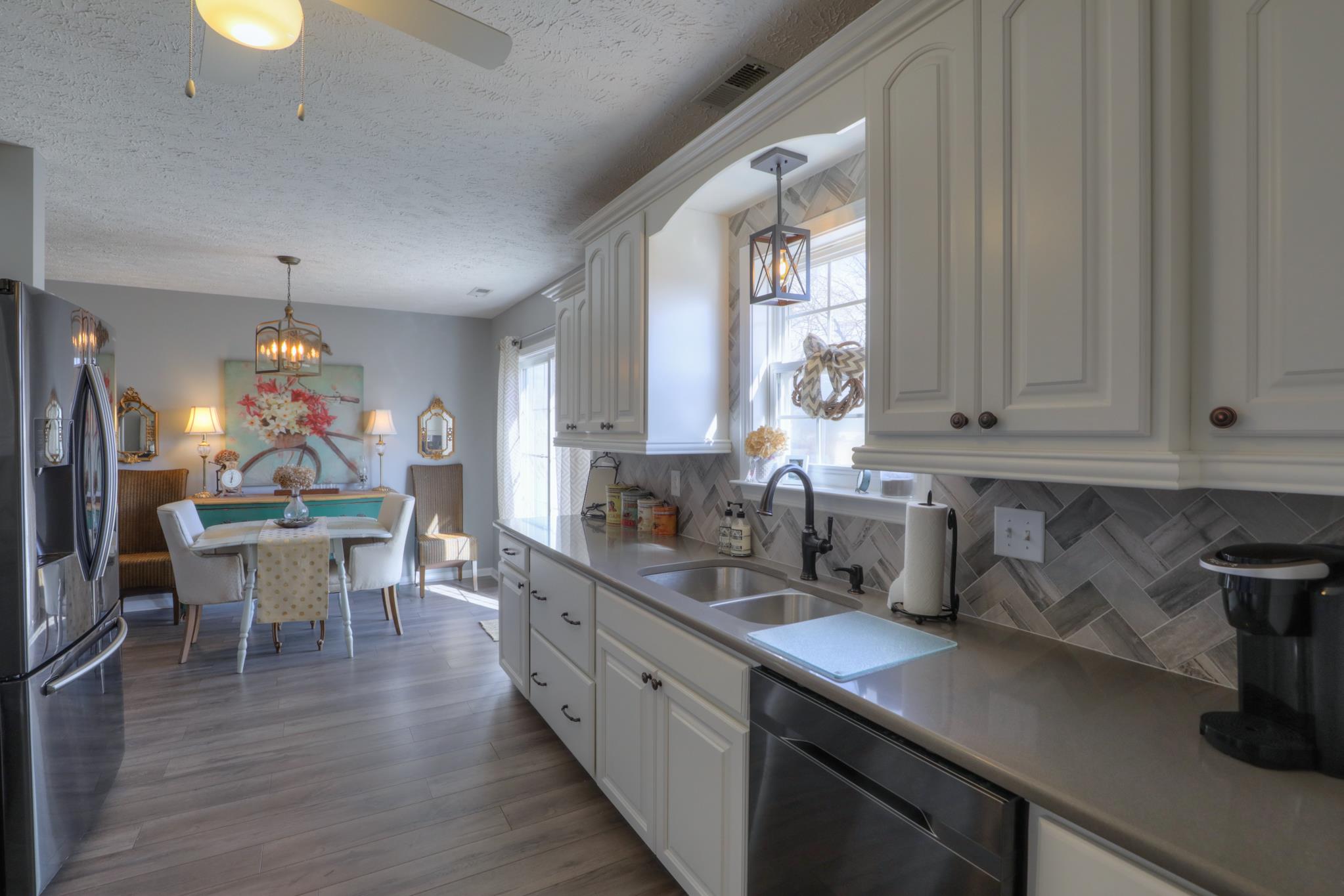 693 Crescent Road Murfreesboro, TN 37128 - Photo 7 of 23 a kitchen with a sink dishwasher a dining table and chairs with wooden floor