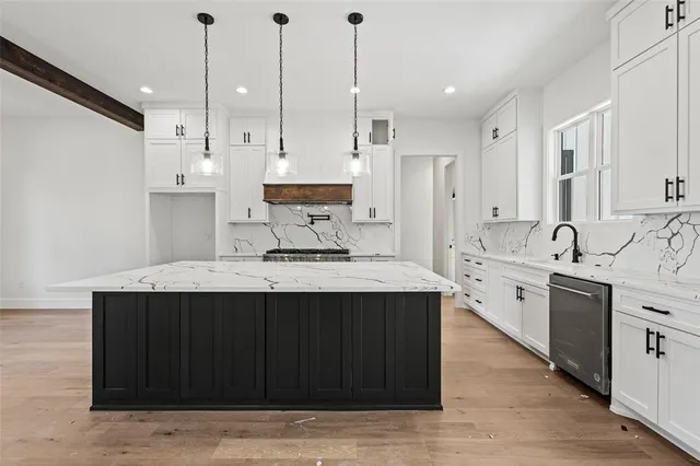 a kitchen with kitchen island granite countertop a sink stainless steel appliances and cabinets