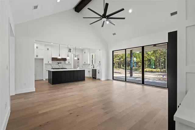 a large kitchen with stainless steel appliances granite countertop a stove and a large window