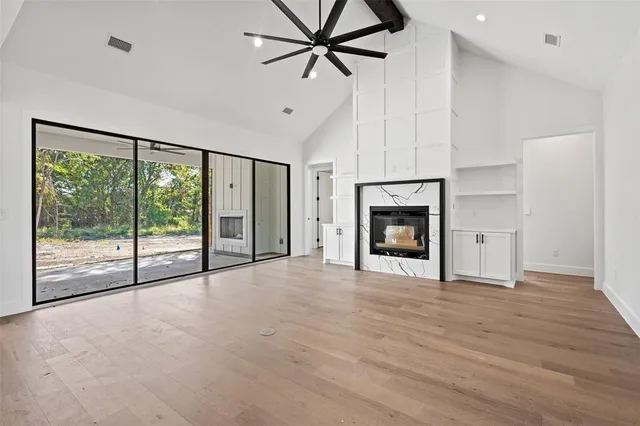a view of an empty room with a fireplace and a window