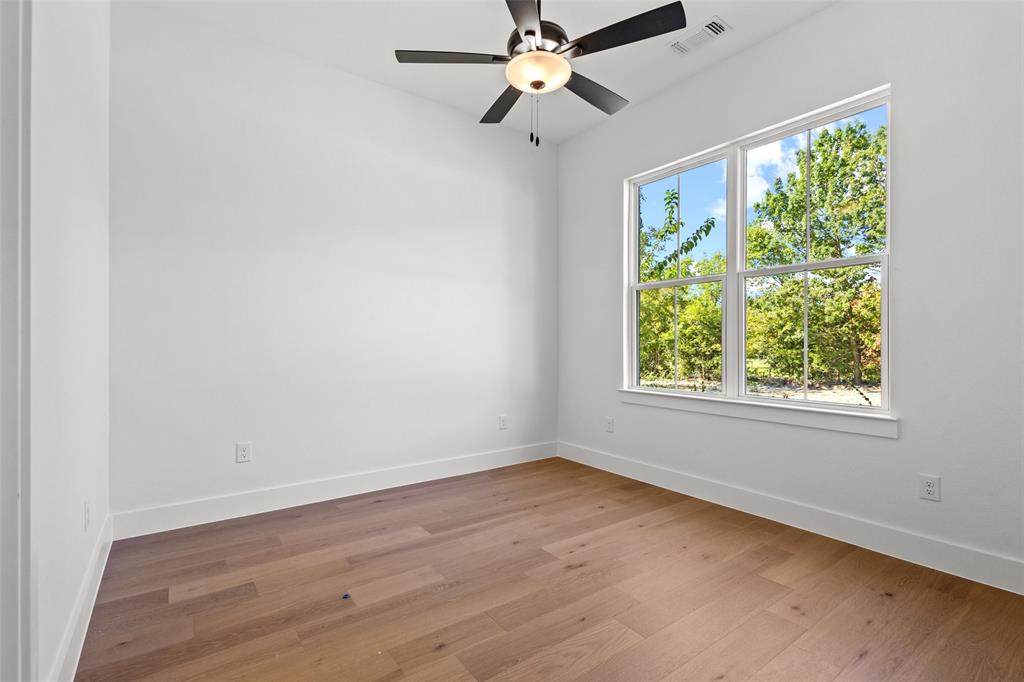 1418 Oak Hill Road Van Alstyne, TX 75495 - Photo 23 of 39 an empty room with wooden floor fan and a window