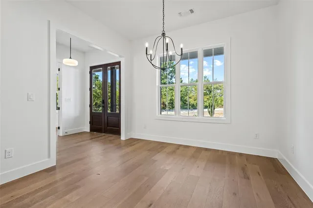 a view of empty room with wooden floor and window