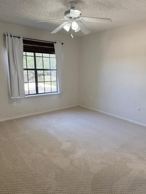 5626 Preston Oaks Road, Unit 4A Dallas, TX 75254 - Photo 4 of 15 an empty room with a chandelier fan and windows