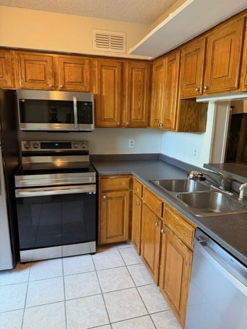 5626 Preston Oaks Road, Unit 4A Dallas, TX 75254 - Photo 10 of 15 a kitchen with stainless steel appliances a sink dishwasher stove and microwave