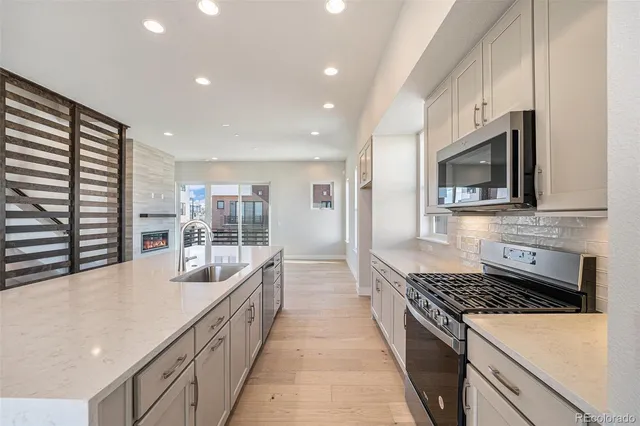 a large kitchen with stainless steel appliances granite countertop a lot of counter space and a sink