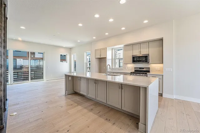 a large kitchen with kitchen island a sink stainless steel appliances and cabinets
