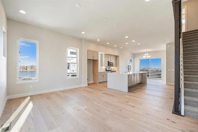 a view of kitchen with kitchen island wooden floor center island and stainless steel appliances