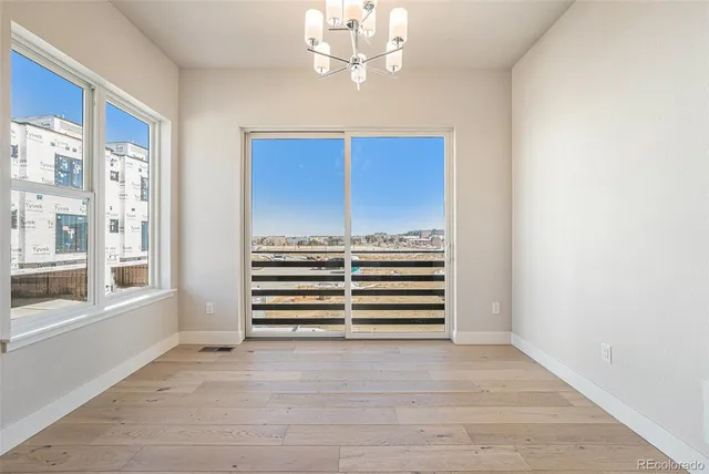 a view of a kitchen with kitchen island stainless steel appliances wooden floor and windows