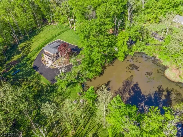 an aerial view of a house with a yard and lake view