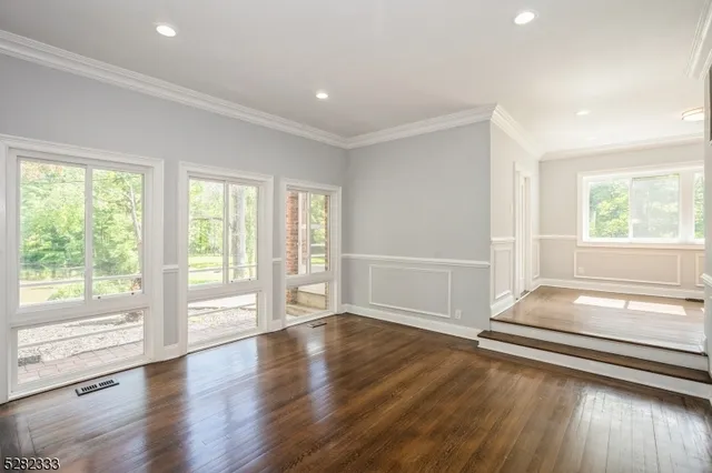 a view of a livingroom with furniture a fireplace and wooden floor