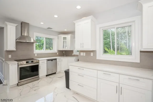 a kitchen with granite countertop a sink stove and refrigerator