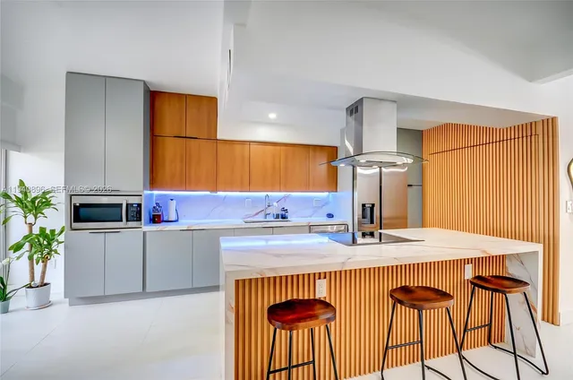 a kitchen with stainless steel appliances kitchen island granite countertop a sink and white cabinets