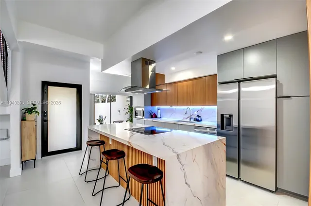 a kitchen with a sink a refrigerator a stove and chairs