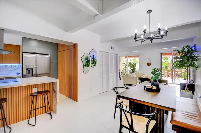 a dining room with furniture potted plants and a chandelier