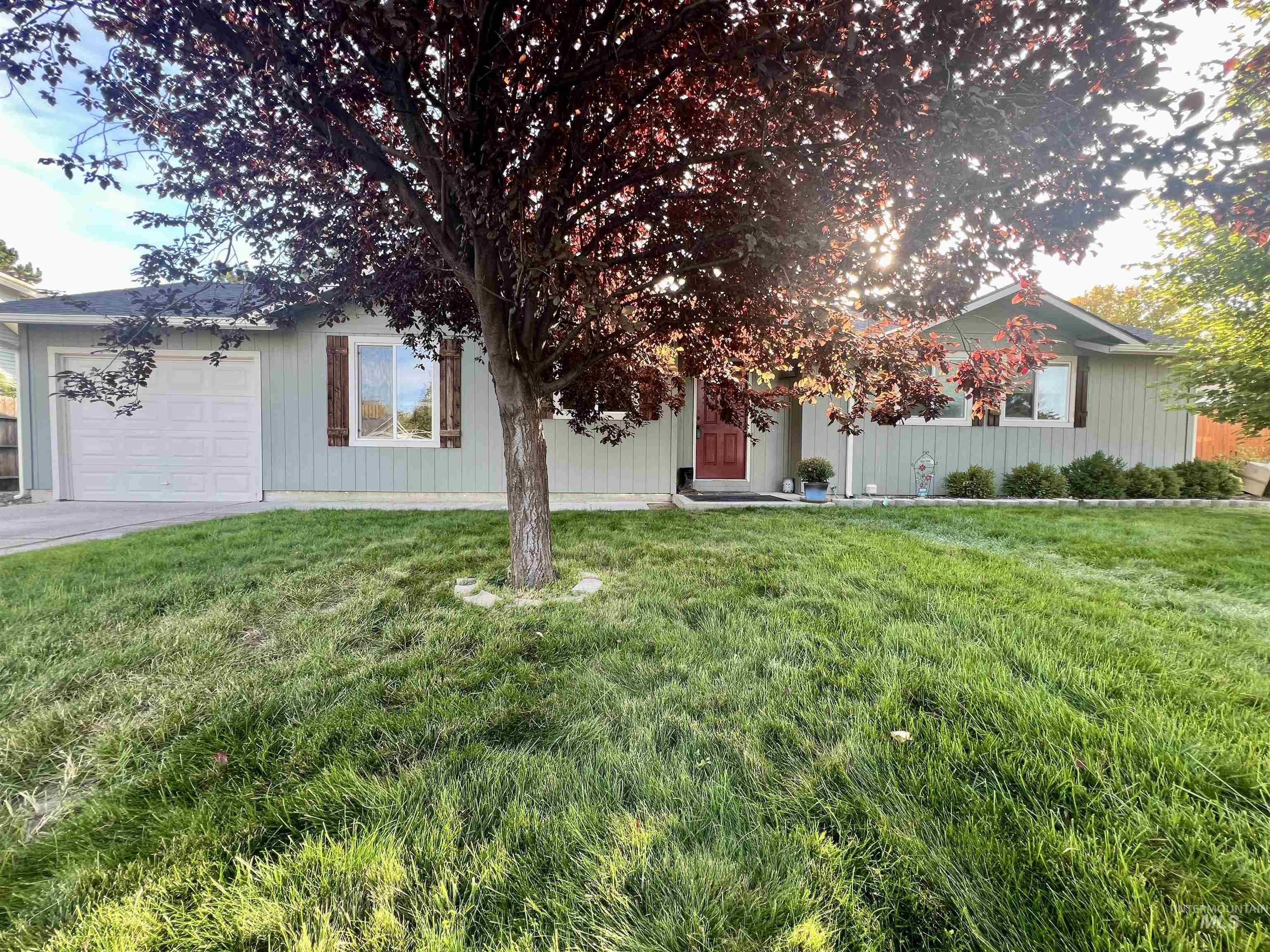 View of front of property with a front lawn, an attached garage, and driveway