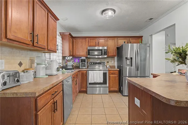 a kitchen with a sink a microwave a refrigerator and cabinets