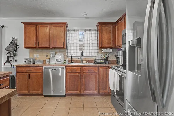 a kitchen with stainless steel appliances granite countertop a refrigerator sink and microwave