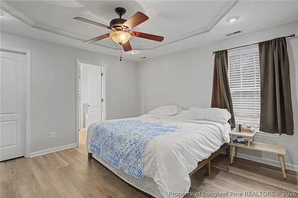 a bedroom with a bed ceiling fan and a window
